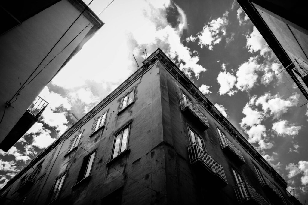 Low angle monochrome view of an urban building with dramatic clouds.